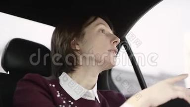 穿着白色衬衫和栗色毛衣的棕色头发的漂亮女人坐在车里，解释去她家的正确方式